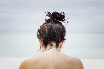 woman facing seashore with wet hair