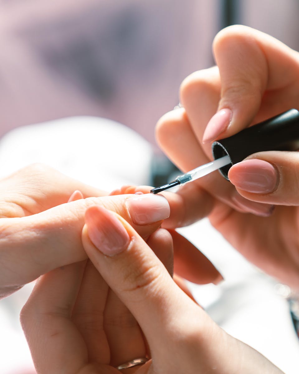 Close-up of a Cosmetician Painting Womans Nails