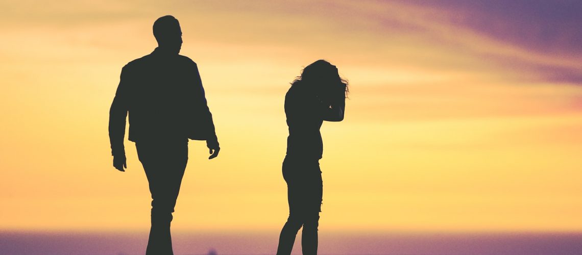 silhouette of man and woman under yellow sky